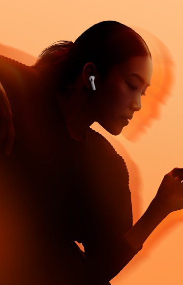 Osoba nosi AirPods 5, savijene ruke, šarena pozadina